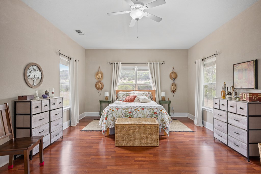 659 Town Creek Road Kerrville, TX 78028 - Photo 12 of 65 a spacious bedroom with a bed and wooden floor