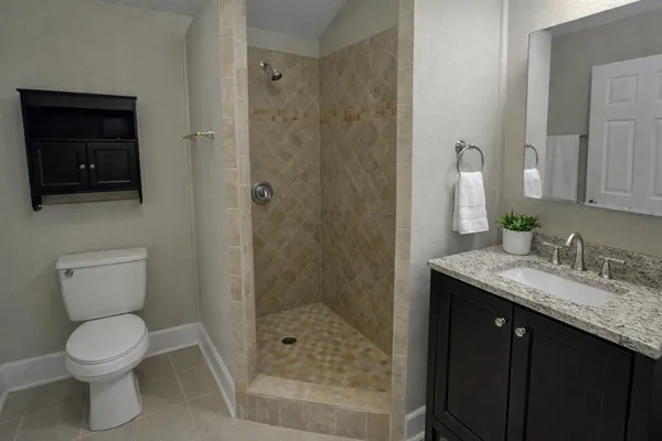 a bathroom with a granite countertop sink toilet and shower