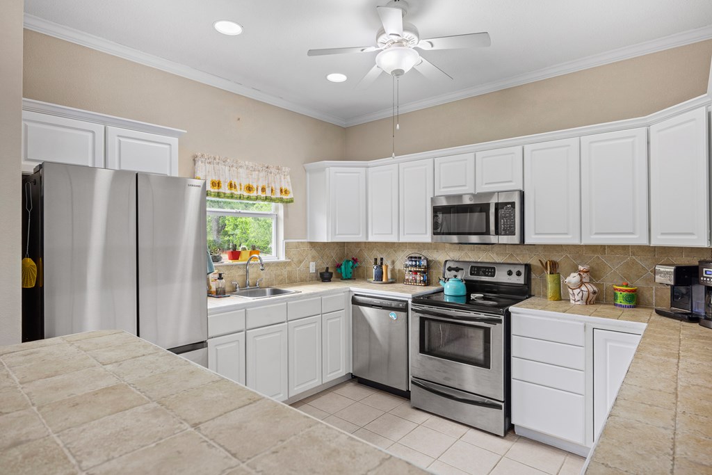 659 Town Creek Road Kerrville, TX 78028 - Photo 10 of 65 a kitchen with stainless steel appliances a refrigerator sink and microwave