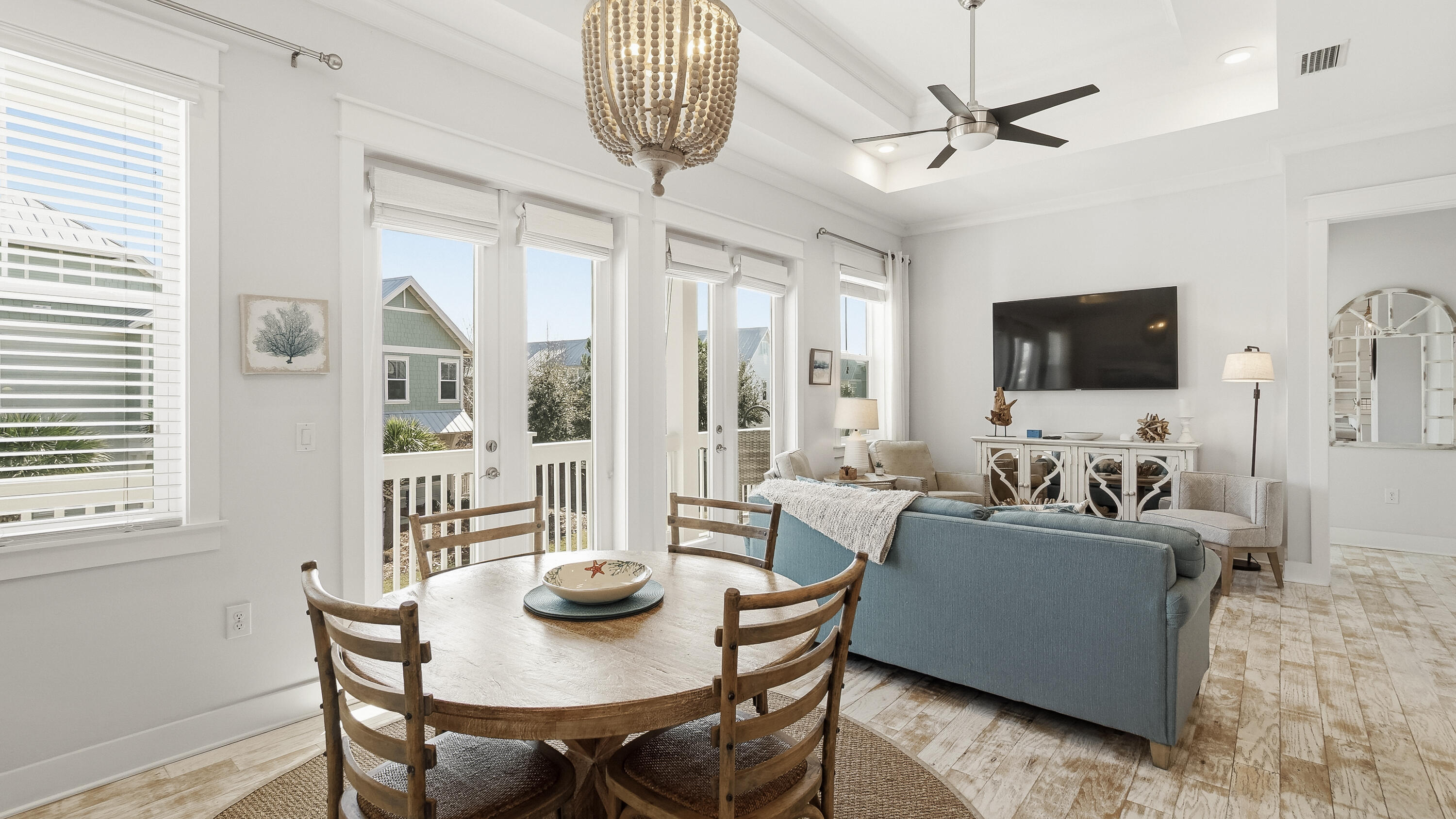 a living room with furniture a chandelier and a flat screen tv
