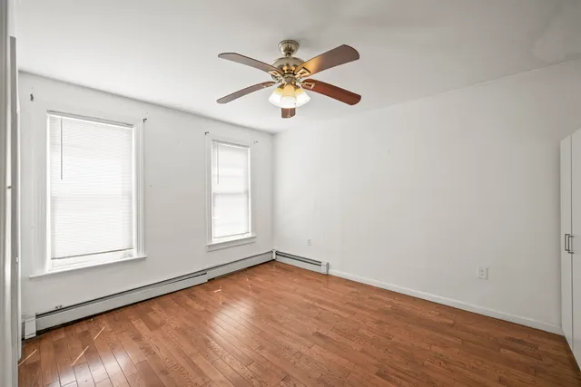 an empty room with window and wooden floor