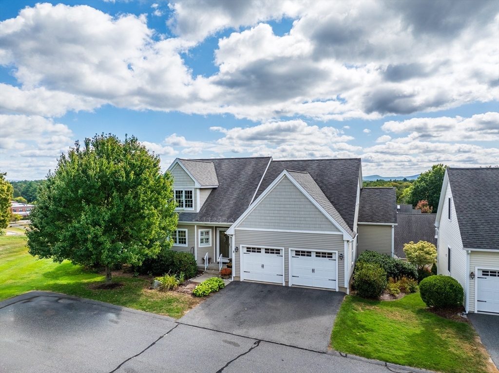 a view of house with garden and tall tress