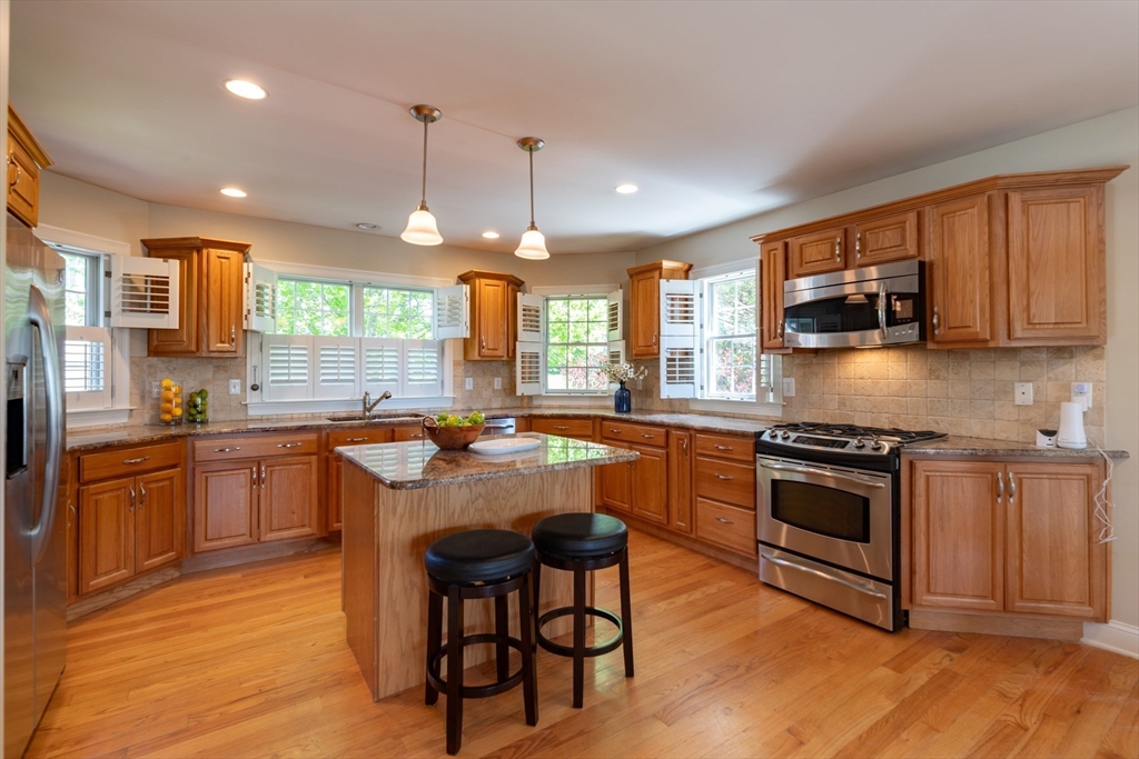 20 Bridge Road, Unit 8 Northampton, MA 01062 - Photo 11 of 32 a kitchen with stainless steel appliances granite countertop wooden cabinets a sink a stove a dining table and chairs