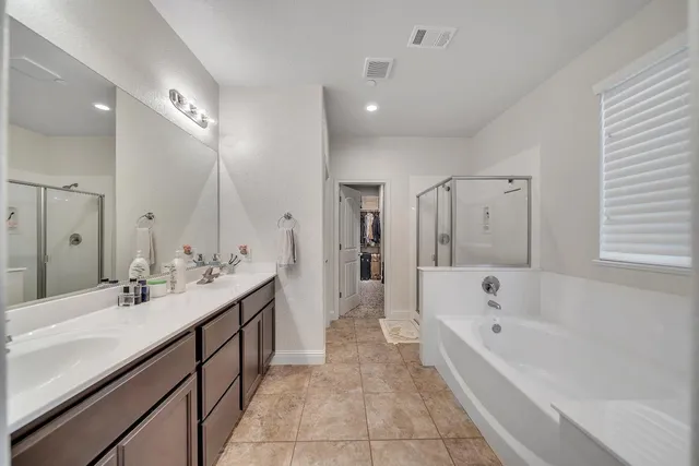 a spacious bathroom with a bathtub shower and sink
