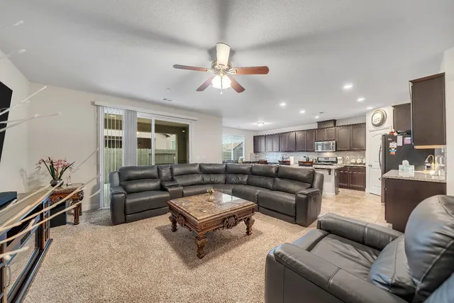 a living room with furniture ceiling fan and a fireplace