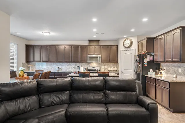 a kitchen with a dining table chairs refrigerator and stove