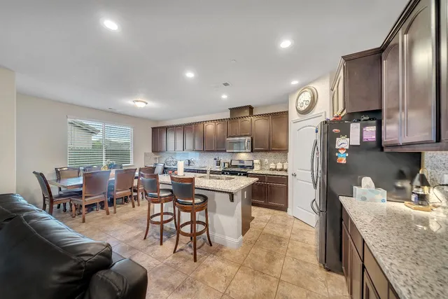 a kitchen with stainless steel appliances granite countertop a sink stove and refrigerator