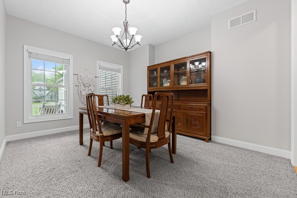 369 Eldridge Road Aurora, OH 44202 - Photo 10 of 50 Dining space with a chandelier and light colored carpet