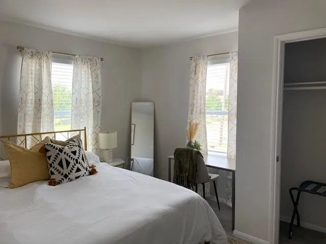 a bedroom with a bed and a large window