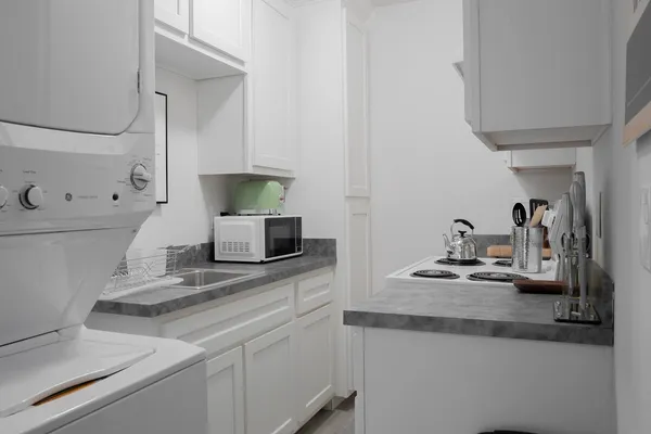 a kitchen with sink stove and wooden floor