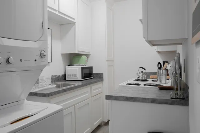 a kitchen with sink stove and wooden floor