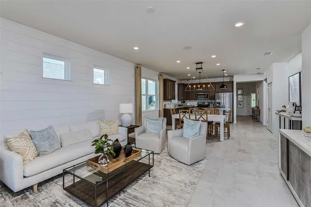 a living room with furniture and view of kitchen