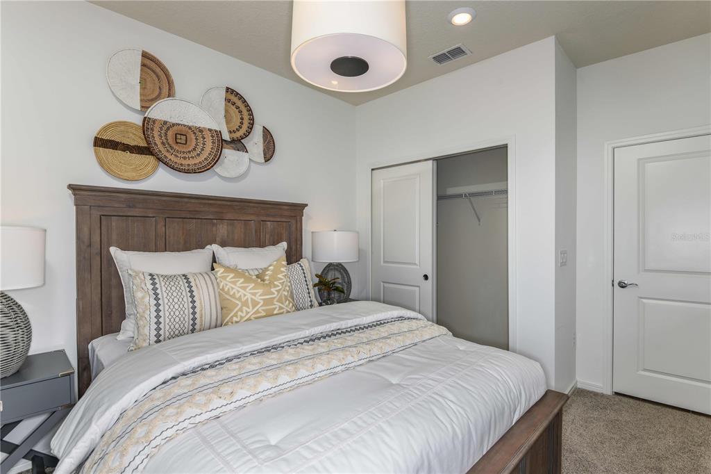 2354 Dew Drop Loop St. Cloud, FL 34771 - Photo 19 of 31 a bedroom with a bed and flowerpot