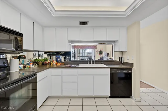 a kitchen with a sink dishwasher stove and cabinets