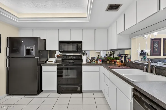 a kitchen with a sink a refrigerator and cabinets