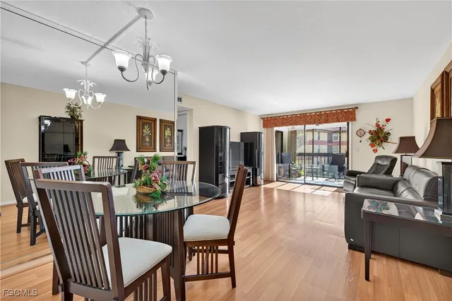 a view of a dining room with furniture a chandelier and wooden floor