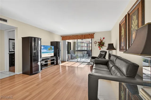 a livingroom with furniture a flat screen tv and floor to ceiling window