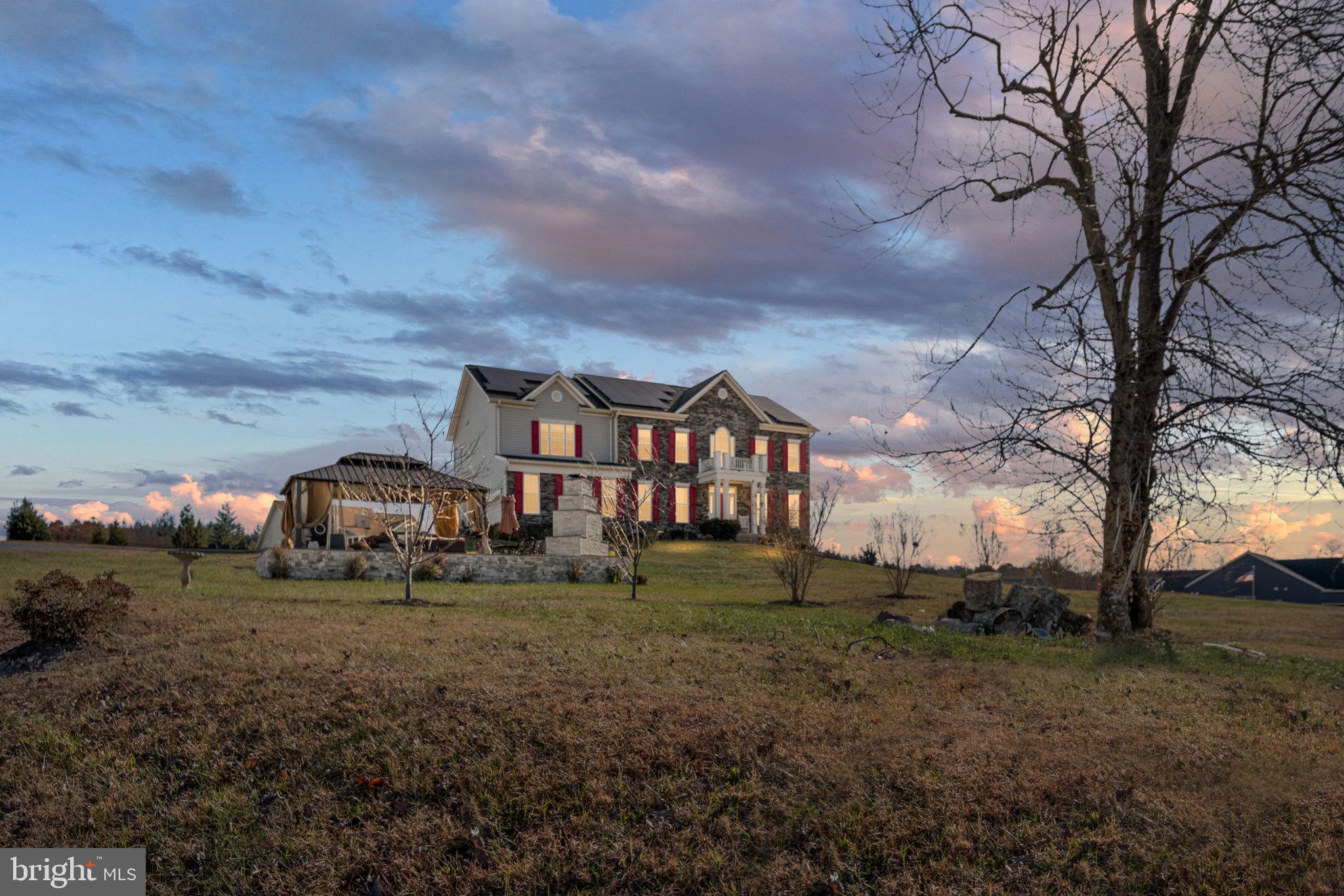 9590 Blackbird Loop Culpeper, VA 22701 - Photo 2 of 76 a view of a big house with a big yard and large trees
