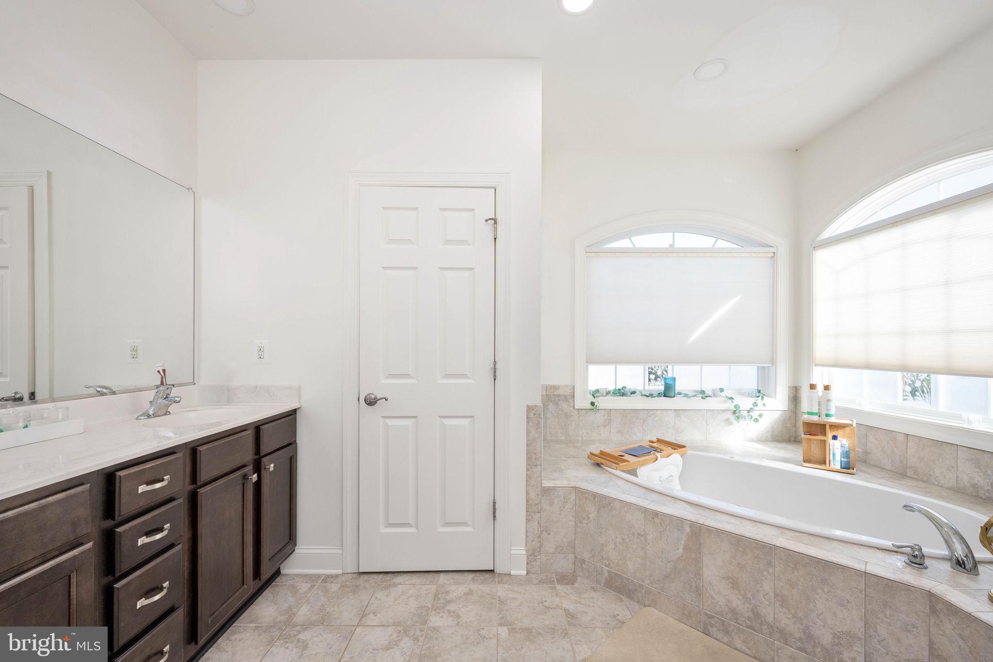 9590 Blackbird Loop Culpeper, VA 22701 - Photo 61 of 76 a spacious bathroom with a tub double sink and mirror