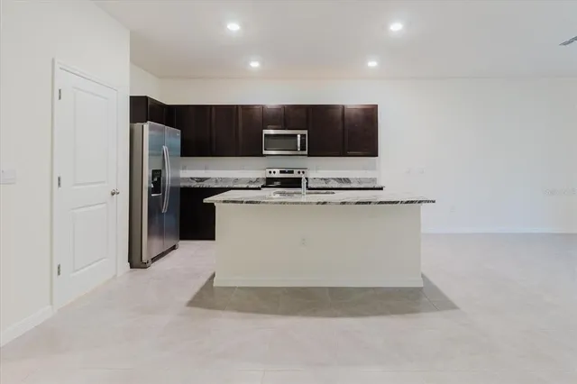 a kitchen with stainless steel appliances granite countertop a refrigerator and a stove top oven