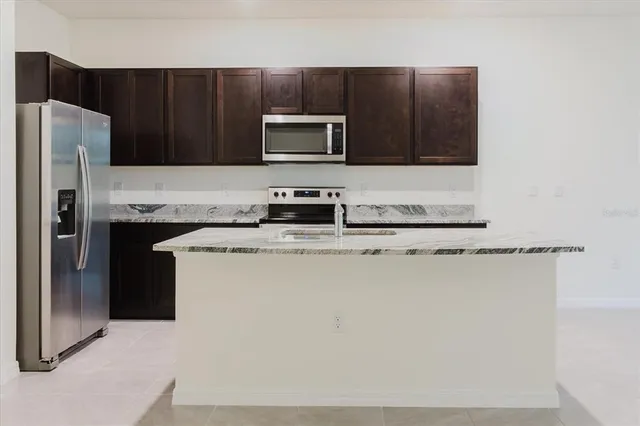 a kitchen with stainless steel appliances granite countertop a sink and a stove