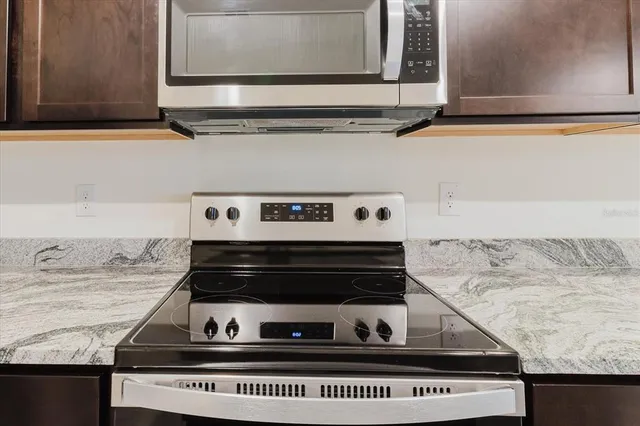 a view of kitchen with stainless steel appliances a microwave a sink and a refrigerator