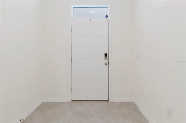 a white toilet sitting next to a white wall