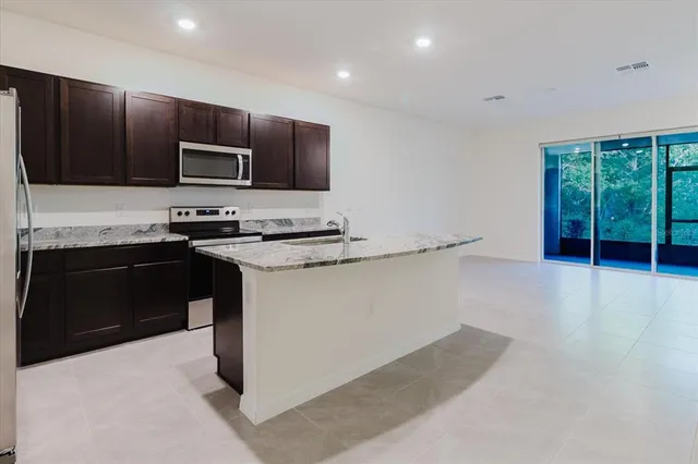 a kitchen with kitchen island a sink stainless steel appliances and cabinets