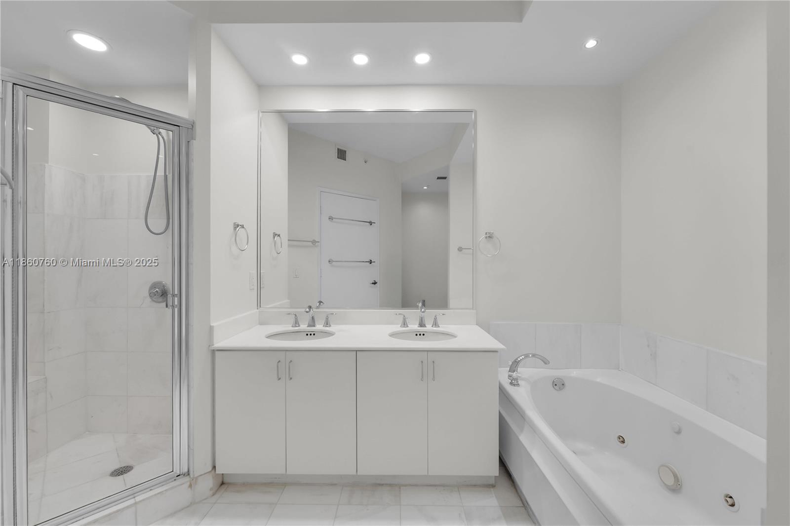 1 Century Lane, Unit 202 Miami Beach, FL 33139 - Photo 18 of 28 a bathroom with a bathtub a shower a sink and a mirror