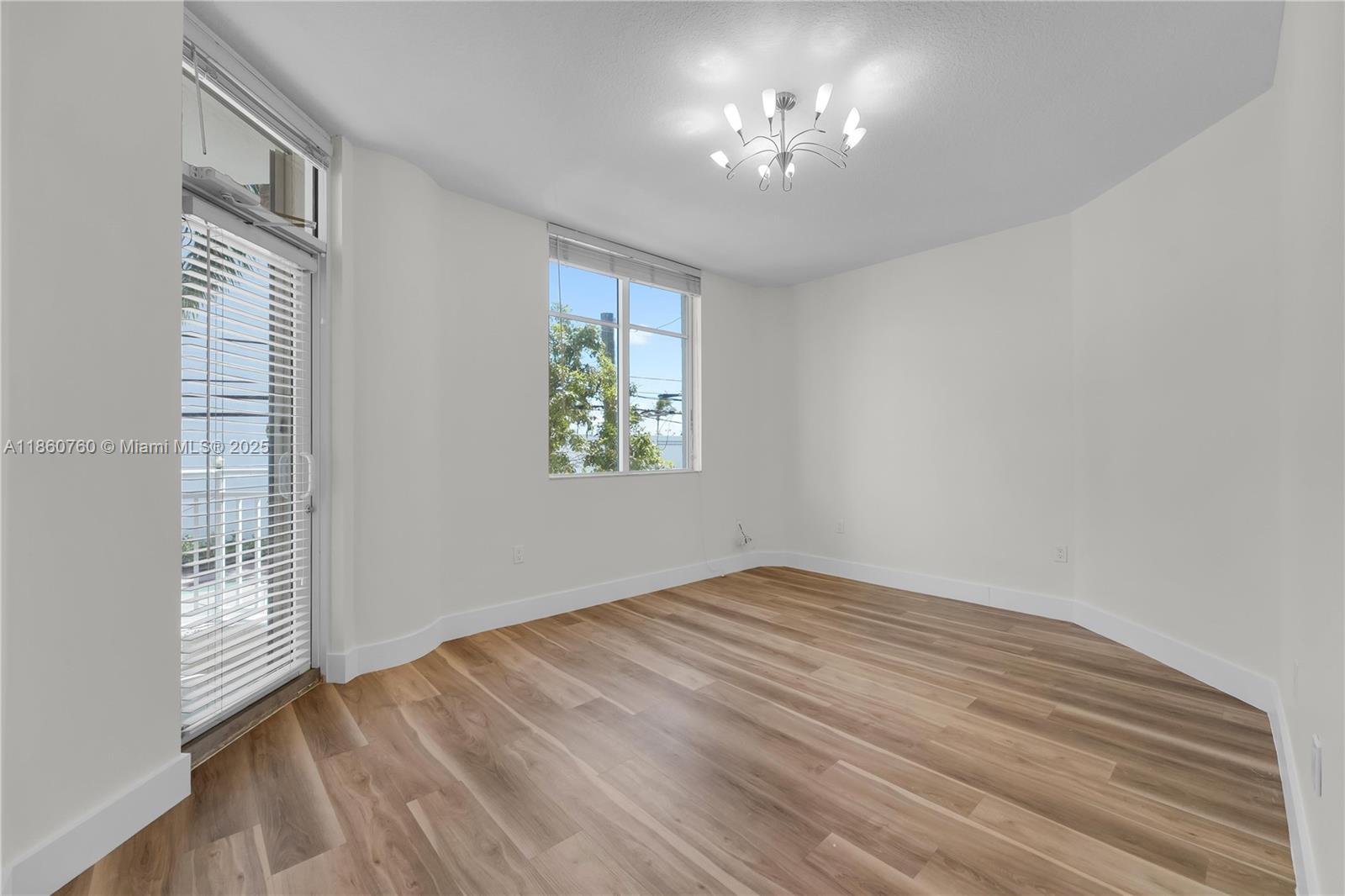 1 Century Lane, Unit 202 Miami Beach, FL 33139 - Photo 20 of 28 a view of empty room with wooden floor and fan