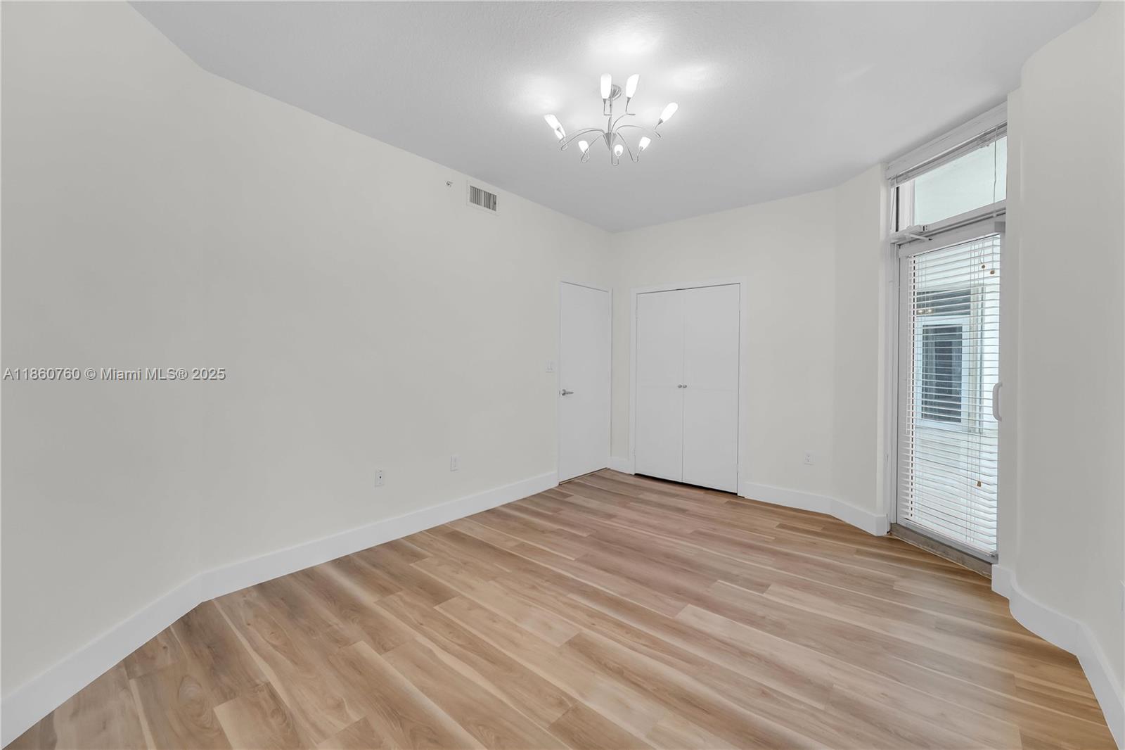 1 Century Lane, Unit 202 Miami Beach, FL 33139 - Photo 21 of 28 a view of an empty room with a chandelier fan