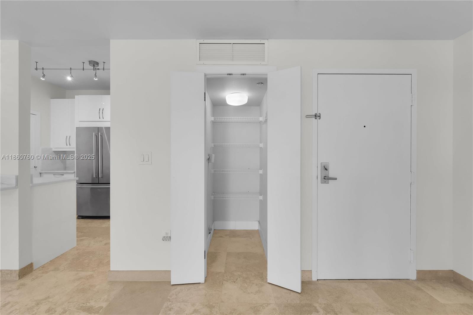 1 Century Lane, Unit 202 Miami Beach, FL 33139 - Photo 25 of 28 a view of a kitchen with a refrigerator and cabinets