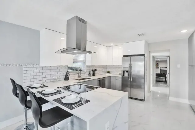 a kitchen with stainless steel appliances kitchen island a table and chairs