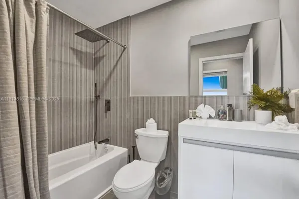 a en suite bathroom with a granite countertop toilet and a mirror