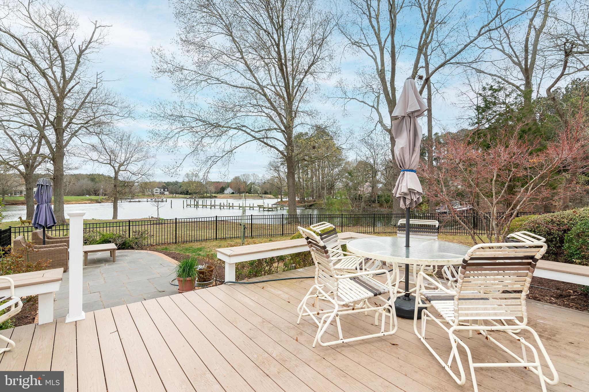 4752 Sailors Retreat Road Oxford, MD 21654 - Photo 6 of 22 a view of a patio with dining table and chairs with wooden floor and fence
