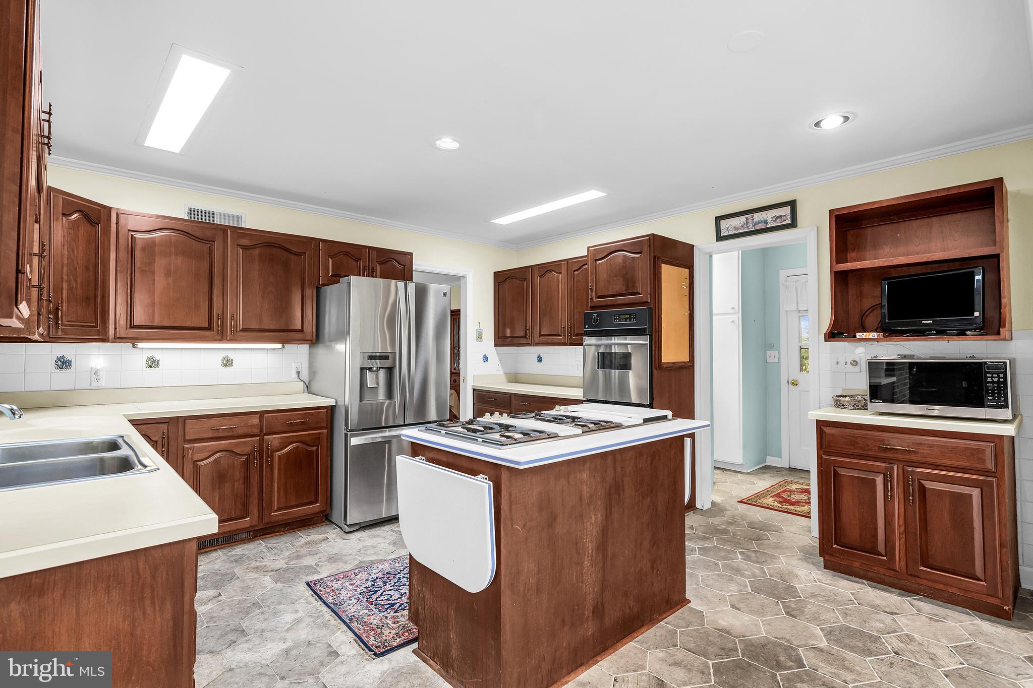 4752 Sailors Retreat Road Oxford, MD 21654 - Photo 10 of 22 a kitchen with stainless steel appliances granite countertop a stove top oven a refrigerator a sink and dishwasher
