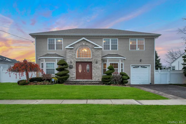 a front view of a house with a garden and plants