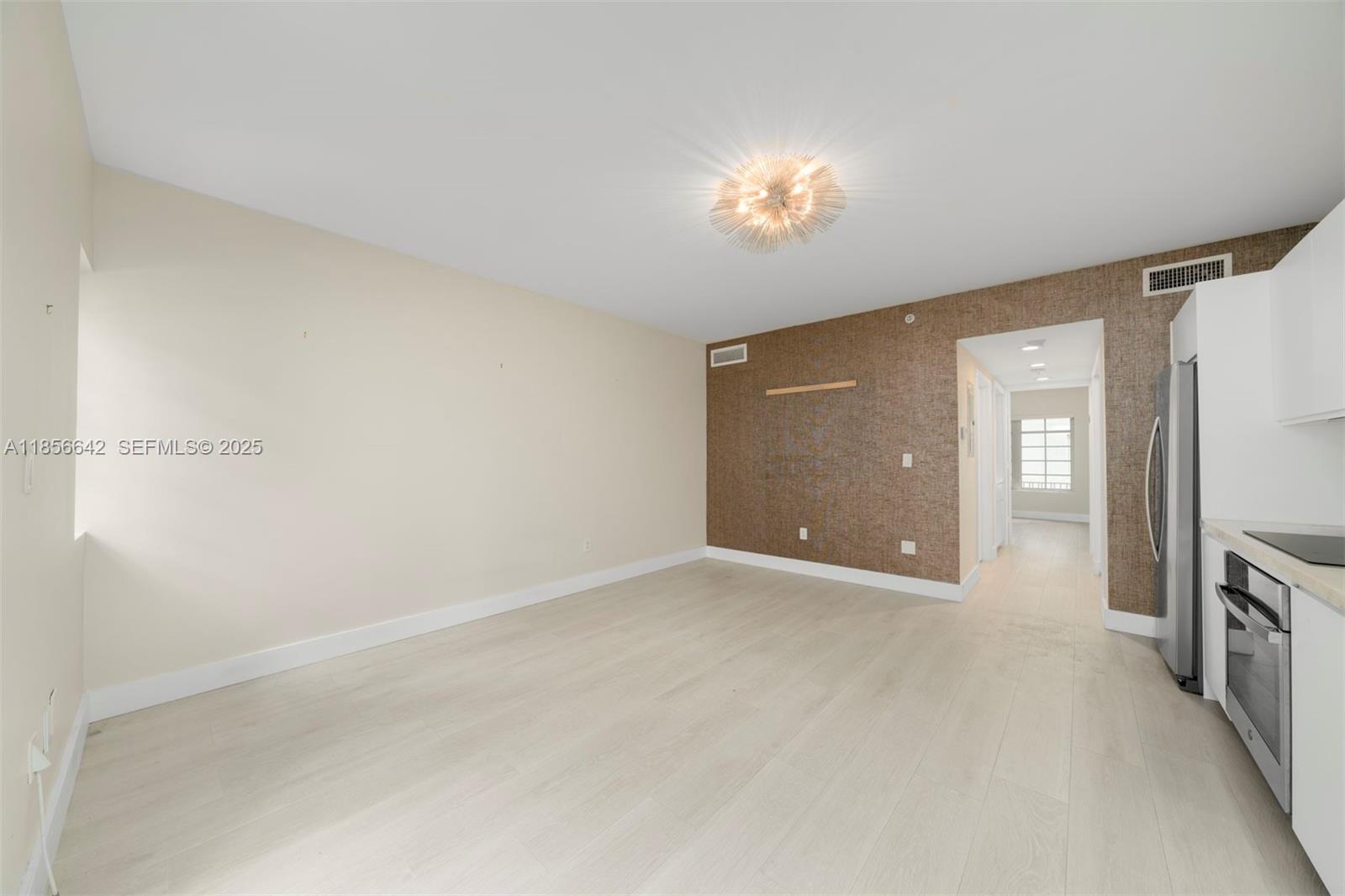 435 21st Street, Unit 103 Miami Beach, FL 33139 - Photo 13 of 20 an empty room with chandelier fan