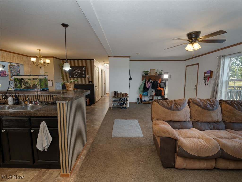 4391 Sandy Lake Road Ravenna, OH 44266 - Photo 13 of 30 Living room with crown molding, light carpet, a chandelier, and a ceiling fan