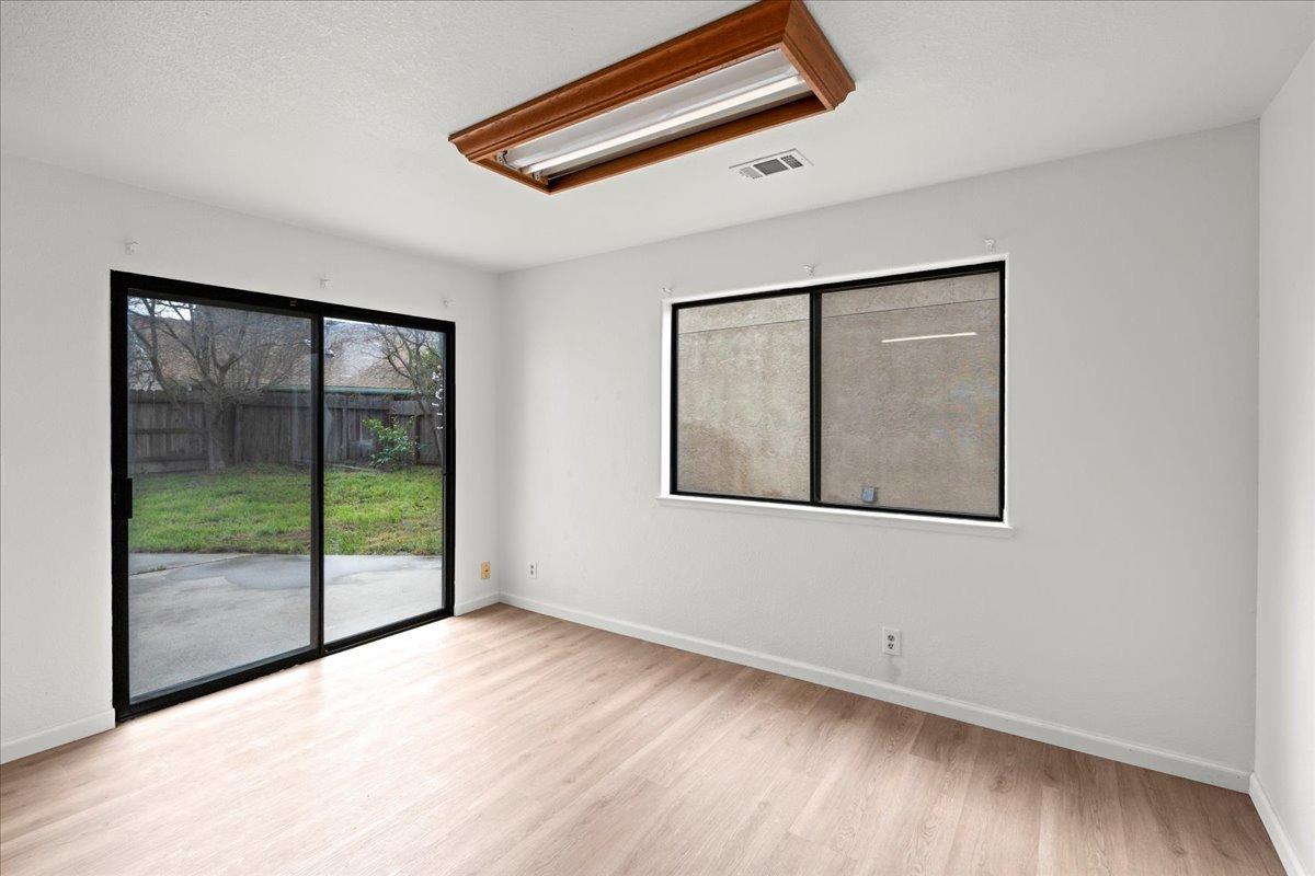 938 Snowgoose Lane Manteca, CA 95337 - Photo 8 of 16 a view of an empty room with wooden floor and windows