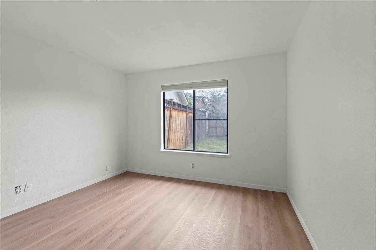 938 Snowgoose Lane Manteca, CA 95337 - Photo 9 of 16 an empty room with wooden floor and windows