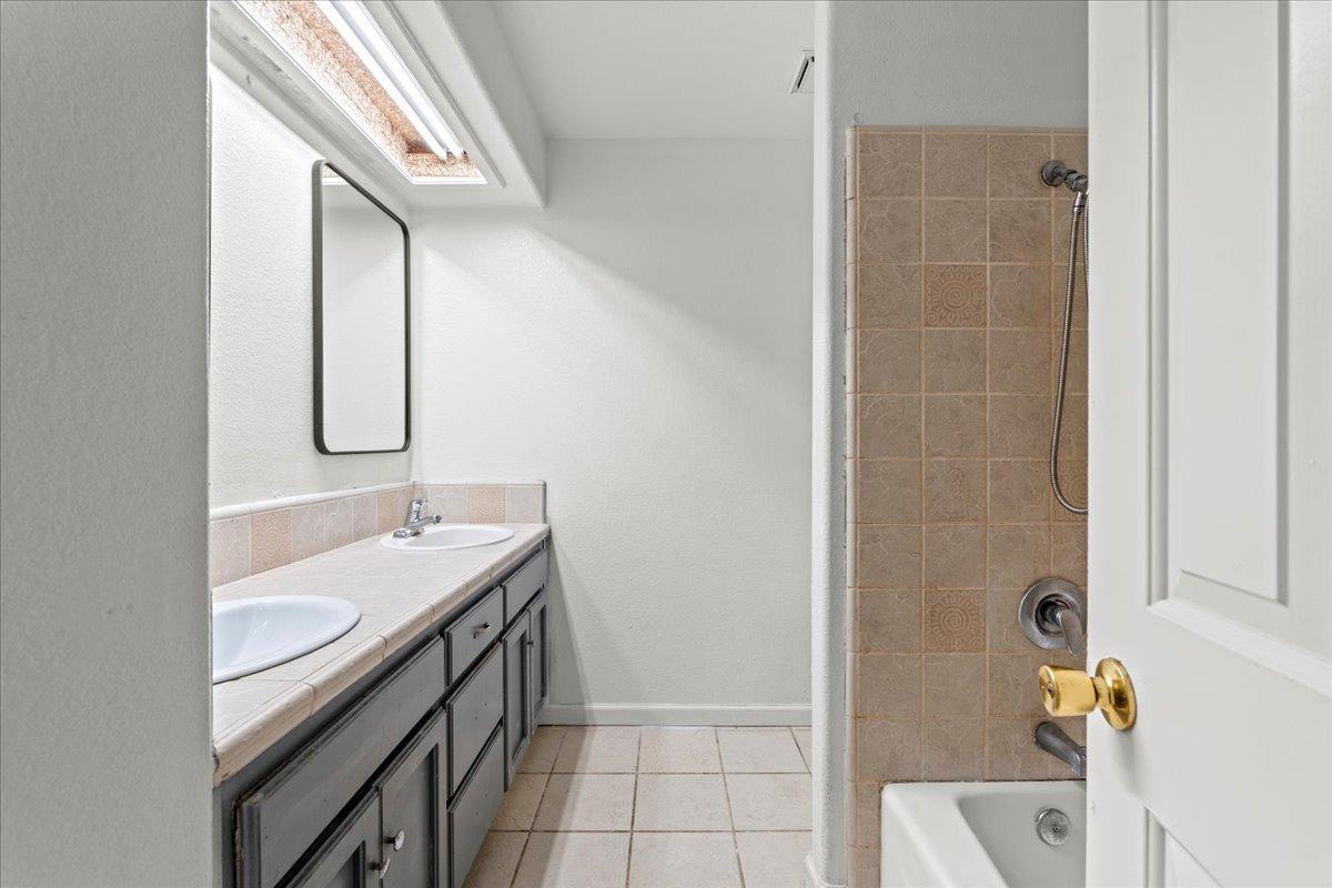 938 Snowgoose Lane Manteca, CA 95337 - Photo 10 of 16 a bathroom with a granite countertop sink and a mirror