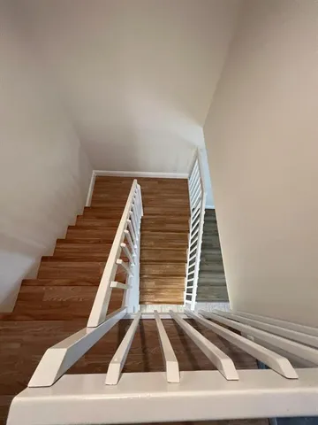 a view of staircase with railing and white walls