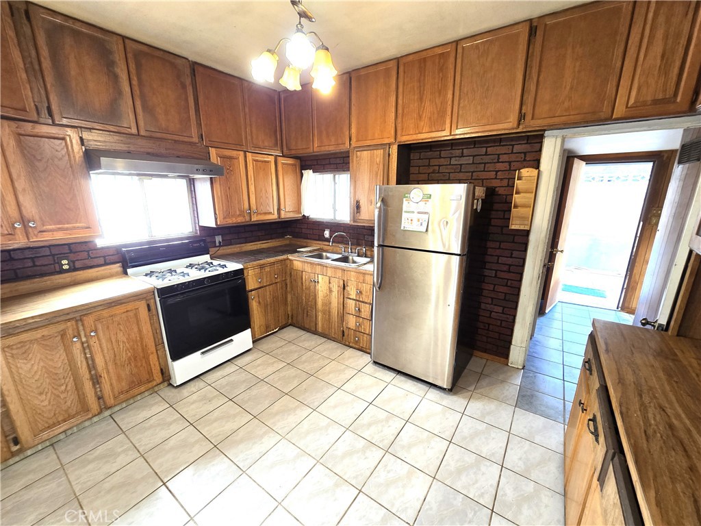 2789 Fairmount Boulevard Riverside, CA 92501 - Photo 36 of 74 a kitchen with granite countertop a refrigerator a sink dishwasher a stove top oven a refrigerator and cabinets