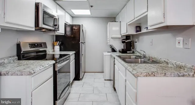a kitchen with stainless steel appliances granite countertop a sink stove microwave and refrigerator