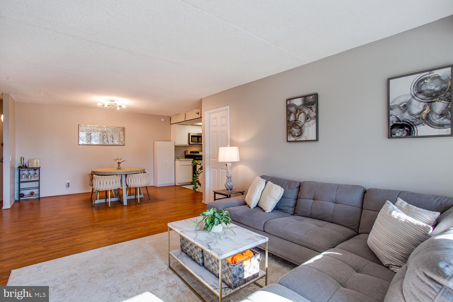 5911 Edsall Road, Unit 206 Alexandria, VA 22304 - Photo 4 of 40 a living room with furniture and a dining table with wooden floor