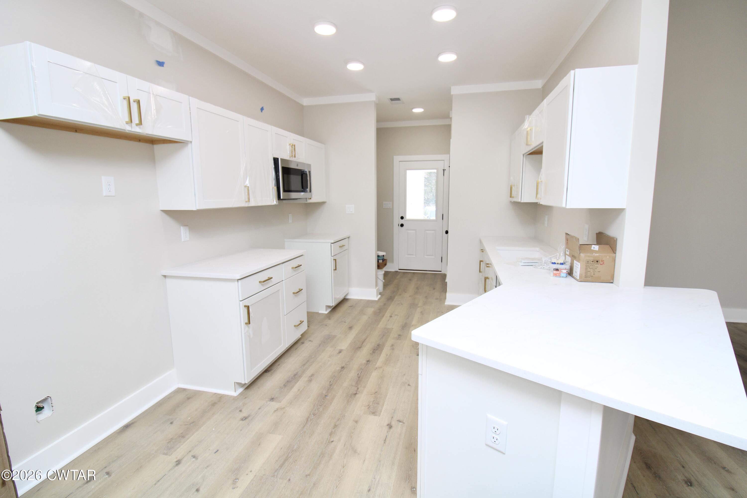25 Weatherstone Drive Jackson, TN 38305 - Photo 3 of 15 a large white kitchen with kitchen island a sink a stove and a refrigerator