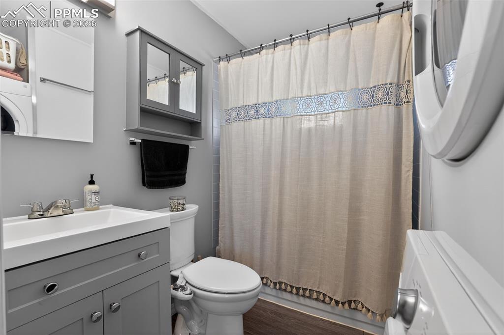 702 Erie Road Colorado Springs, CO 80910 - Photo 4 of 15 Bathroom featuring vanity, dark wood-style flooring, and washer / clothes dryer