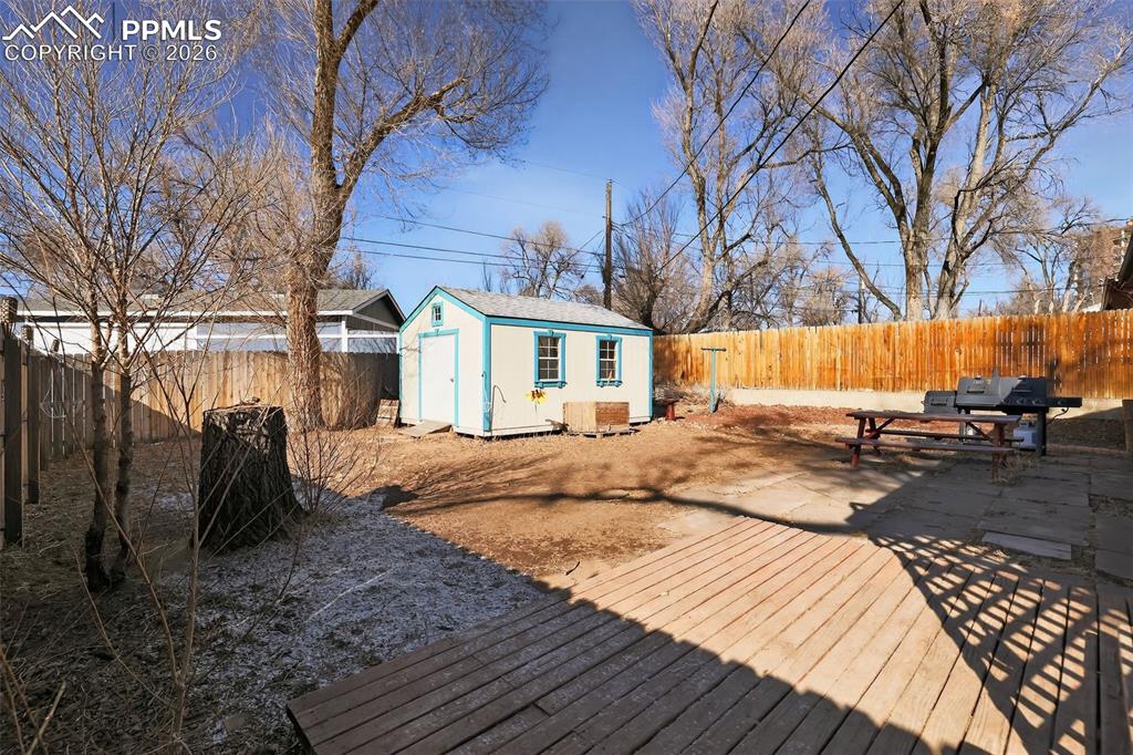 702 Erie Road Colorado Springs, CO 80910 - Photo 8 of 15 Deck featuring a fenced backyard, a storage shed, and a grill