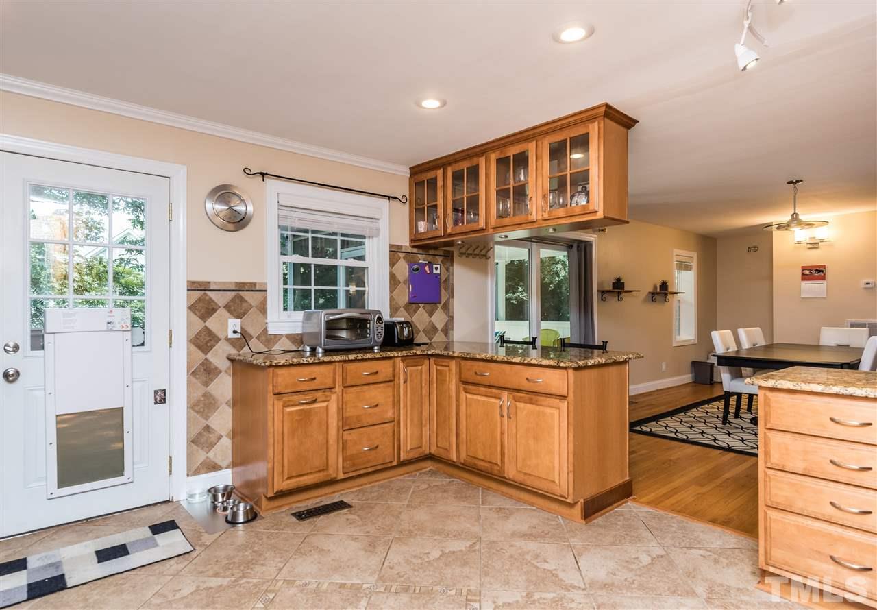 2808 Oberry Street Raleigh, NC 27607 - Photo 8 of 24 a kitchen with stainless steel appliances granite countertop a stove a sink and a refrigerator